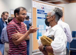 Vena Crichlow and Dr. Pradeep Bathina chatting by posters. 